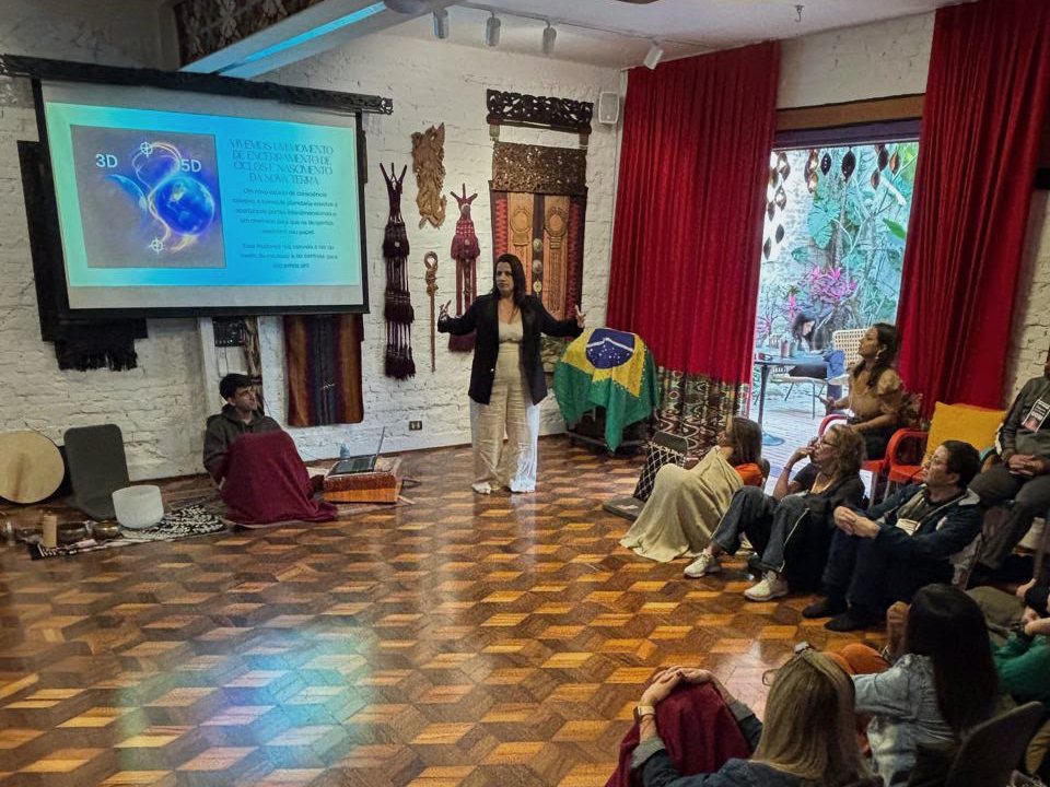 Flávia Reis conduzindo um encontro presencial para uma sala de participantes